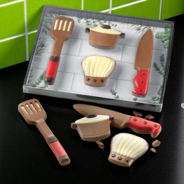 Coffret set de cuisine en chocolat au lait présenté dans une cuisine, création insolite et gourmande pour les passionnés de chocolat et de gastronomie.