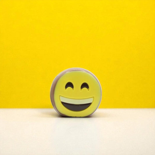 Smiley en chocolat au lait de 50g sur fond jaune, chocolat fondant et joyeux pour un moment de douceur.