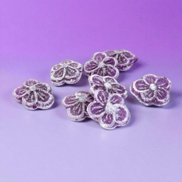 Bonbons violette sur fond violet, confiseries en sucre cuit à la violette de Toulouse, au goût floral délicat.