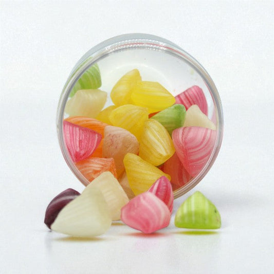 Pot ouvert de bonbons Berlingots multicolores, bonbons durs en sucre cuit aux arômes de fruits assortis.