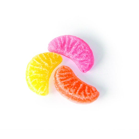 Trois bonbons en tranches colorées représentant les saveurs orange, citron et pamplemousse, confiseries fruitées en sucre cuit.