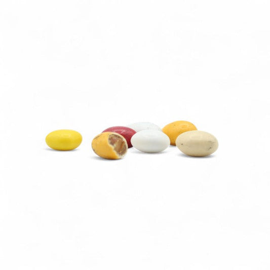 Assortiment Dessertissimo enrobé de chocolat présenté en vrac, mélange gourmand de bouchées chocolatées aux saveurs de tarte citron, crumble fruits rouges, tiramisu et macaron coco.