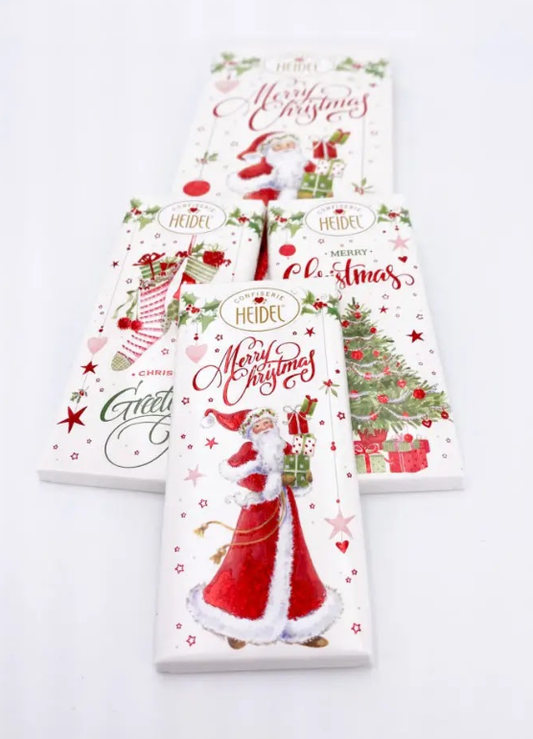 Quatre tablettes de chocolat “Noël blanc” au lait, tablettes gourmandes au papier décoré aux couleurs de Noël.