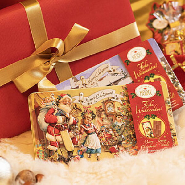 Boîte décorative “Nostalgie” de Noël 120g présentée en cadeau dans une décoration de Noël, coffret en métal au charme rétro et gourmand.