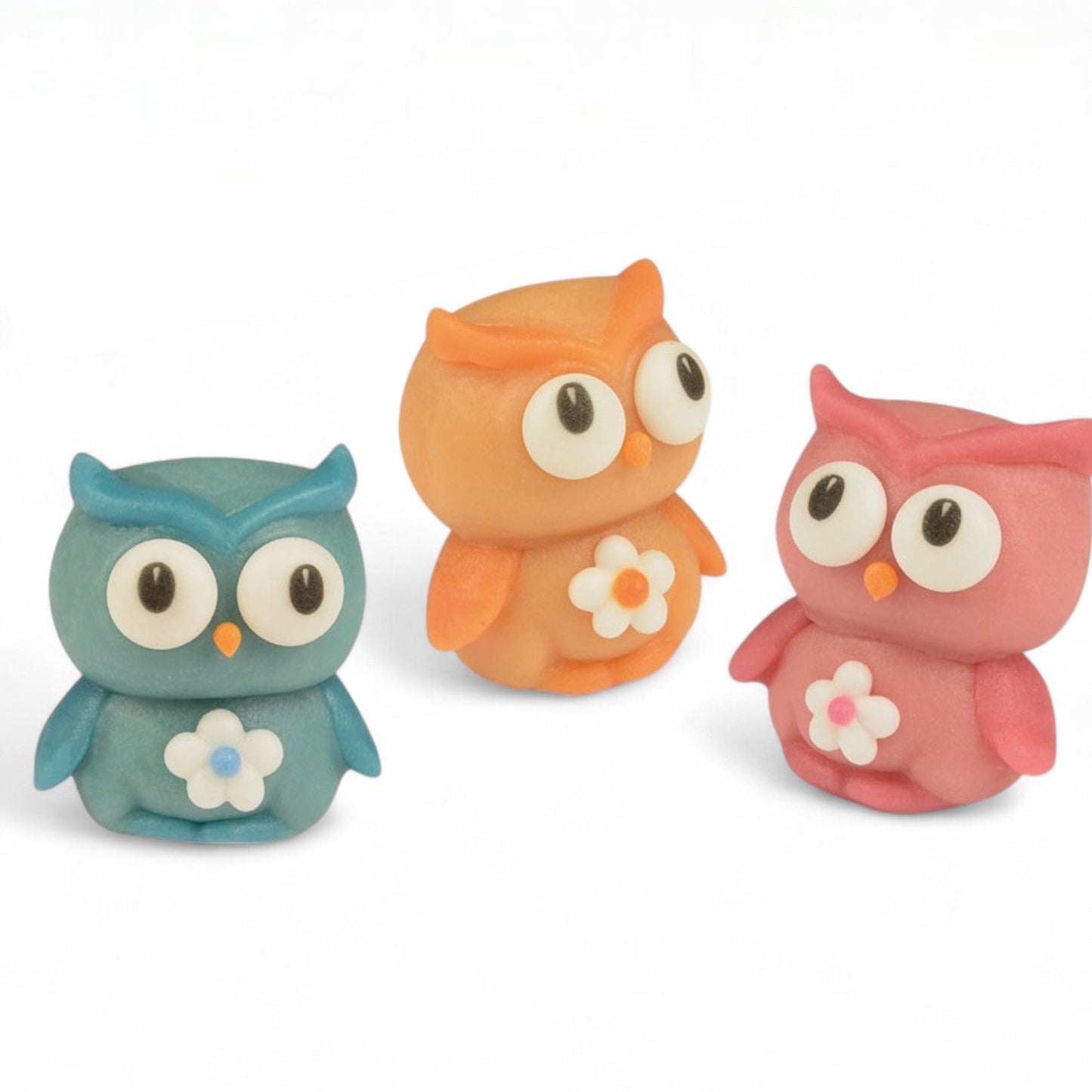 Chouettes en pâte d’amande de couleur bleue, orange et rose, friandises décorées de sucre coloré alliant originalité et gourmandise.