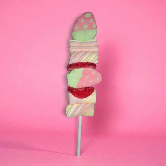 Brochette de guimauve “Fraise” sur fond rose – guimauves moelleuses au goût de fraise, douceur gourmande et colorée.