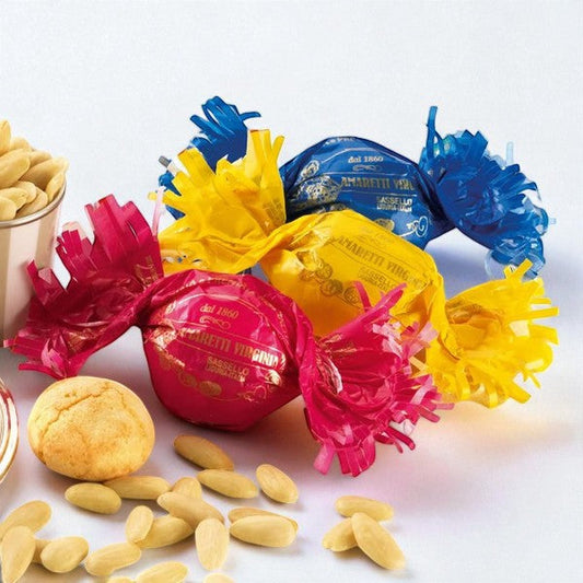 Trois Amaretti moelleux Nature emballés en papillotes colorées rouge, bleu et jaune, biscuits aux amandes tendres.