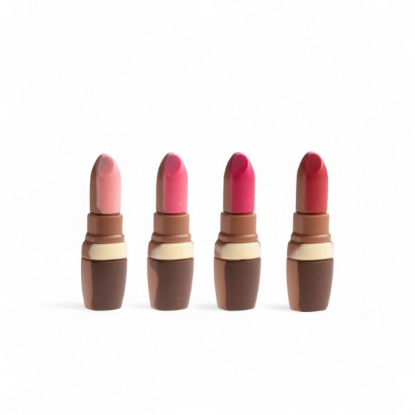 Quatre rouges à lèvres en chocolat au lait décoré, moulage gourmand et original alliant élégance et plaisir sucré.