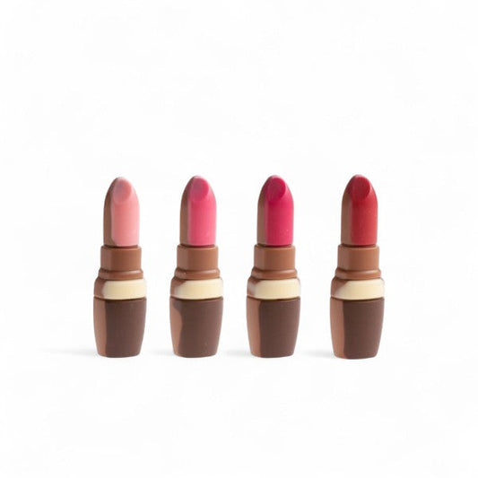 Quatre rouges à lèvres en chocolat au lait décoré, moulage gourmand et original alliant élégance et plaisir sucré.