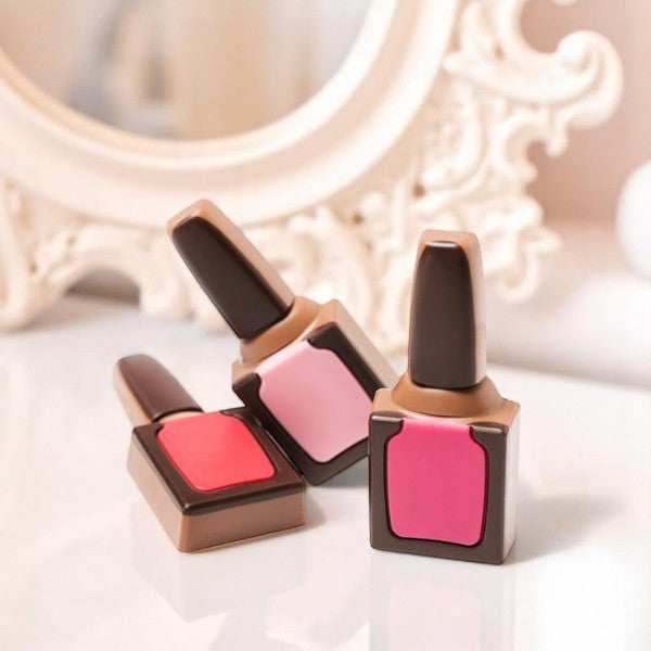 Vernis à ongles en chocolat au lait disposés sur une coiffeuse, création originale mêlant beauté et gourmandise.