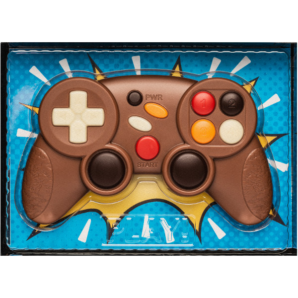 Gros plan sur une manette de jeux vidéo en chocolat au lait, moulage fin et décoré, gourmandise ludique et fondante.