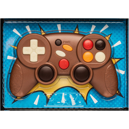 Gros plan sur une manette de jeux vidéo en chocolat au lait, moulage fin et décoré, gourmandise ludique et fondante.