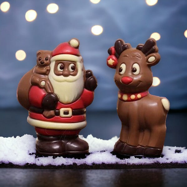 Moulages Père Noël et Renne en chocolat 150g présentés dans un décor d’hiver, chocolats festifs et traditionnels à offrir.