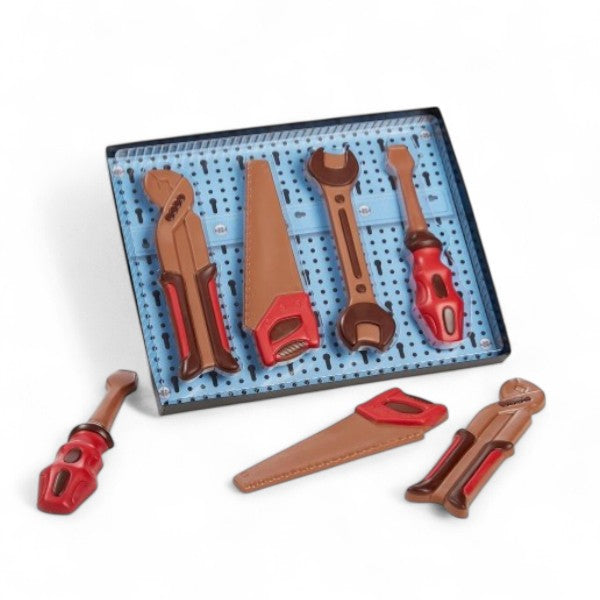 Outils en chocolat au lait – scie, clé plate, tournevis et pince multiprise – création insolite et gourmande pour amateurs de bricolage et de chocolat.