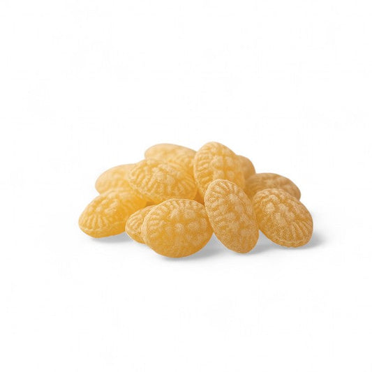Bonbons au miel sur fond blanc, pastilles en sucre cuit dorées au goût authentique de miel.