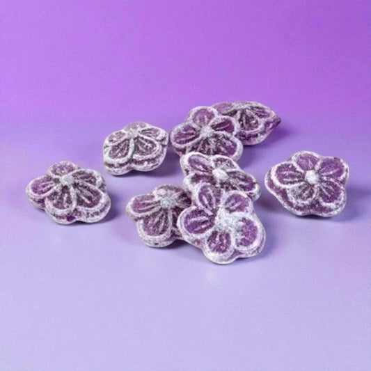 Bonbons violette sur fond violet, confiseries en sucre cuit à la violette de Toulouse, au goût floral délicat.