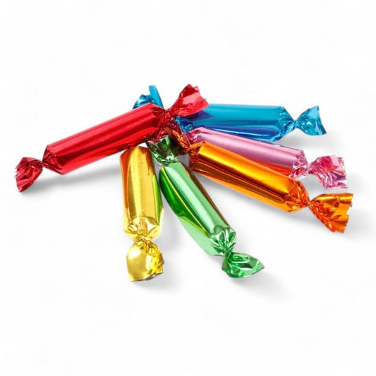 Mini sucres d’orge sur fond blanc, bonbons en sucre cuit multicolores aux saveurs fruitées.