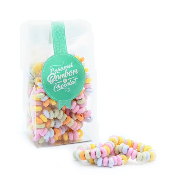 Sachet de colliers de bonbons en dextrose, petits anneaux colorés aux teintes pastel enfilés sur un fil élastique.