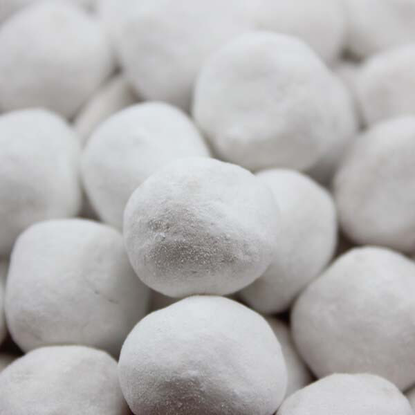 Gros plan sur des bonbons Karaneige en vrac, boules blanches brillantes au cœur tendre de caramel et enrobage de sucre glace.