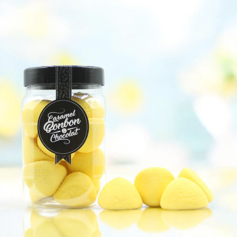 Bonbonnière de guimauves à la banane sur fond bleu – friandises moelleuses et gourmandes au parfum exotique de banane.