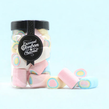 Bonbonnière de guimauves roulées sur fond bleu – friandises colorées et moelleuses en forme de cylindre.