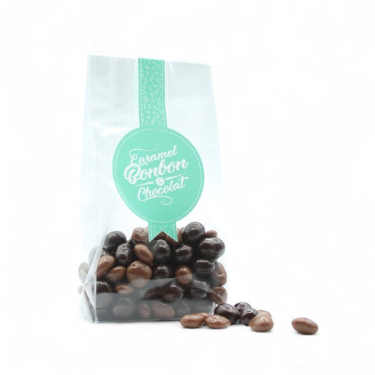 Sachet de raisins secs enrobés de chocolat au lait et noir, confiseries gourmandes alliant douceur fruitée et richesse du cacao.