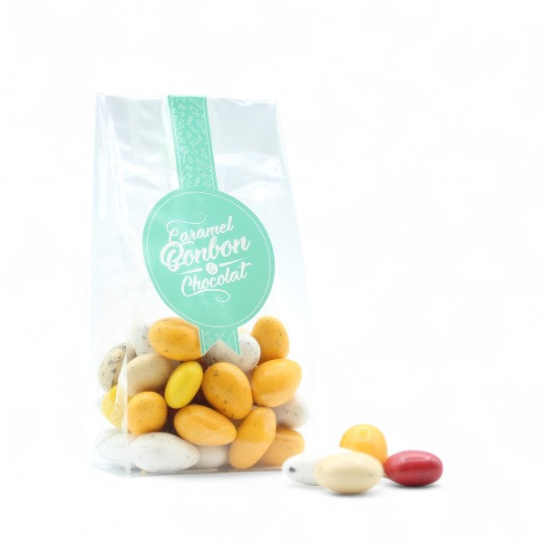 Sachet de Dessertissimo enrobé de chocolat, assortiment de douceurs aux saveurs de desserts variés comme tarte citron, crumble fruits rouges, tarte tatin et macaron coco.