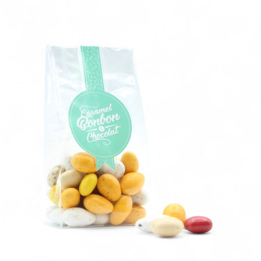 Sachet de Dessertissimo enrobé de chocolat, assortiment de douceurs aux saveurs de desserts variés comme tarte citron, crumble fruits rouges, tarte tatin et macaron coco.