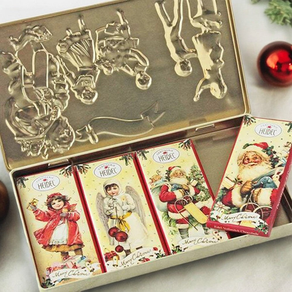 Boîte décorative “Nostalgie” de Noël 120g ouverte, révélant quatre tablettes de chocolat au lait supérieur, cadeau chocolaté raffiné.