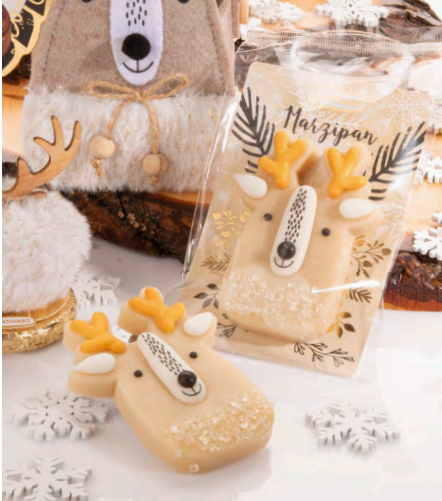 Table de Noël décorée avec des pâtes d’amande en forme de renne, apportant une touche gourmande et festive à la décoration.