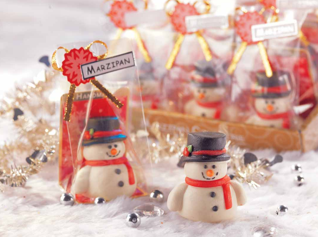 Pâte d’amande Bonhomme de Neige utilisée en décoration de table de Noël, apportant une touche festive et gourmande.