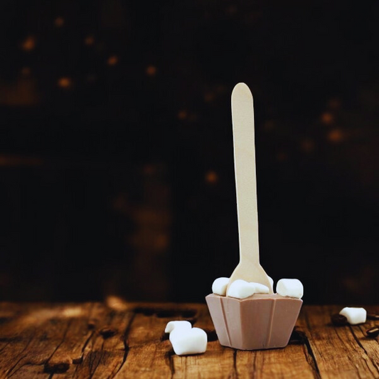 Cuillère à chocolat chaud au lait et mini guimauves sur fond bois – douceur fondante et réconfortante.