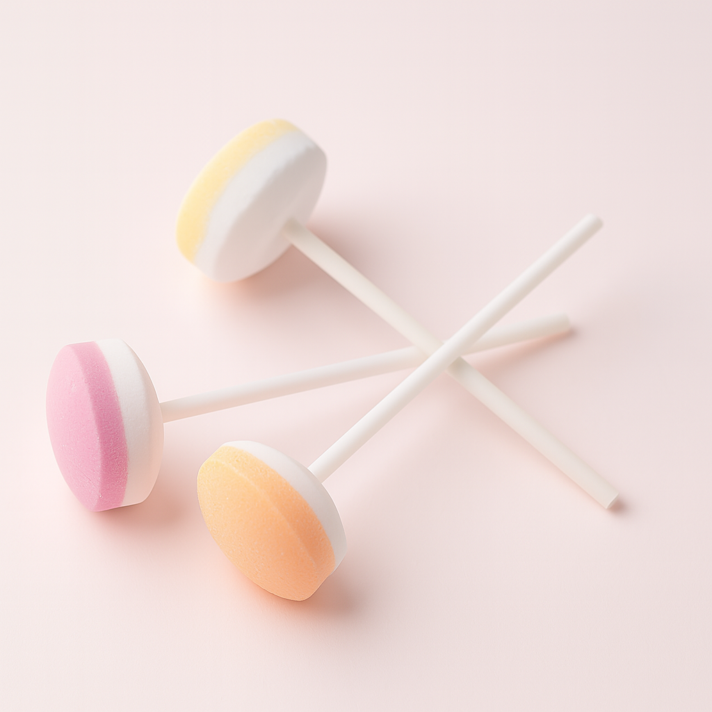 Trois sucettes Lollie Dextrose bicolores sur fond rose pâle – confiseries colorées au goût fruité.