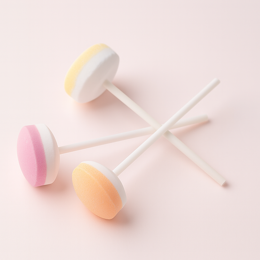 Trois sucettes Lollie Dextrose bicolores sur fond rose pâle – confiseries colorées au goût fruité.