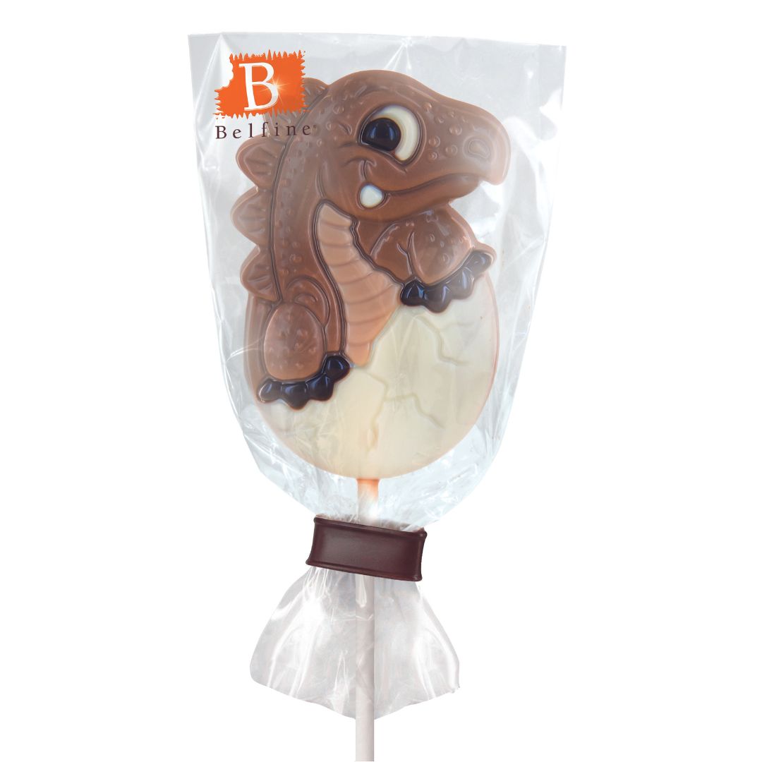 Sucette dinosaure œuf en chocolat au lait emballée, création chocolatée ludique et colorée pour petits gourmands.