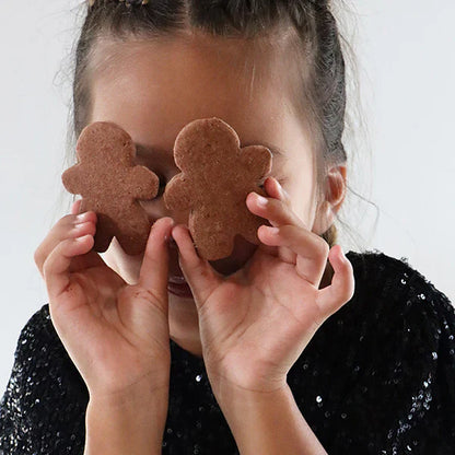 Petite fille cachant ses yeux avec deux biscuits pain d’épices, scène joyeuse et gourmande autour des biscuits faits maison.