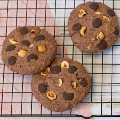 Cookies avoine, chocolat noir et noisettes présentés sur une table, gourmandises bio riches en goût et en texture.