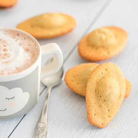 Madeleines au sel de Guérande servies avec une tasse de chocolat chaud, gourmandise bio au goût sucré-salé équilibré.