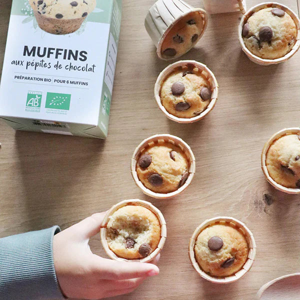 Main prenant un muffin aux pépites de chocolat, biscuit moelleux et fondant préparé avec la préparation bio.