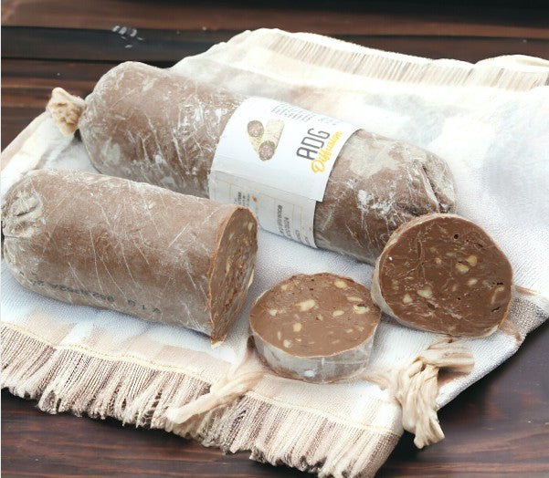 Saucisson au chocolat présenté sur un torchon, chocolat fondant aux noisettes et arachides, dessert trompe-l’œil irrésistible.