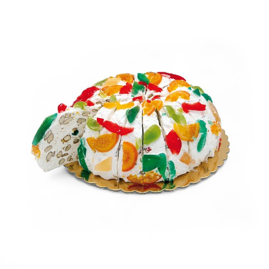 Part de gâteau de nougat aux fruits confits, recette allégée en sucre, confiserie fondante et colorée à base de miel et de fruits confits.