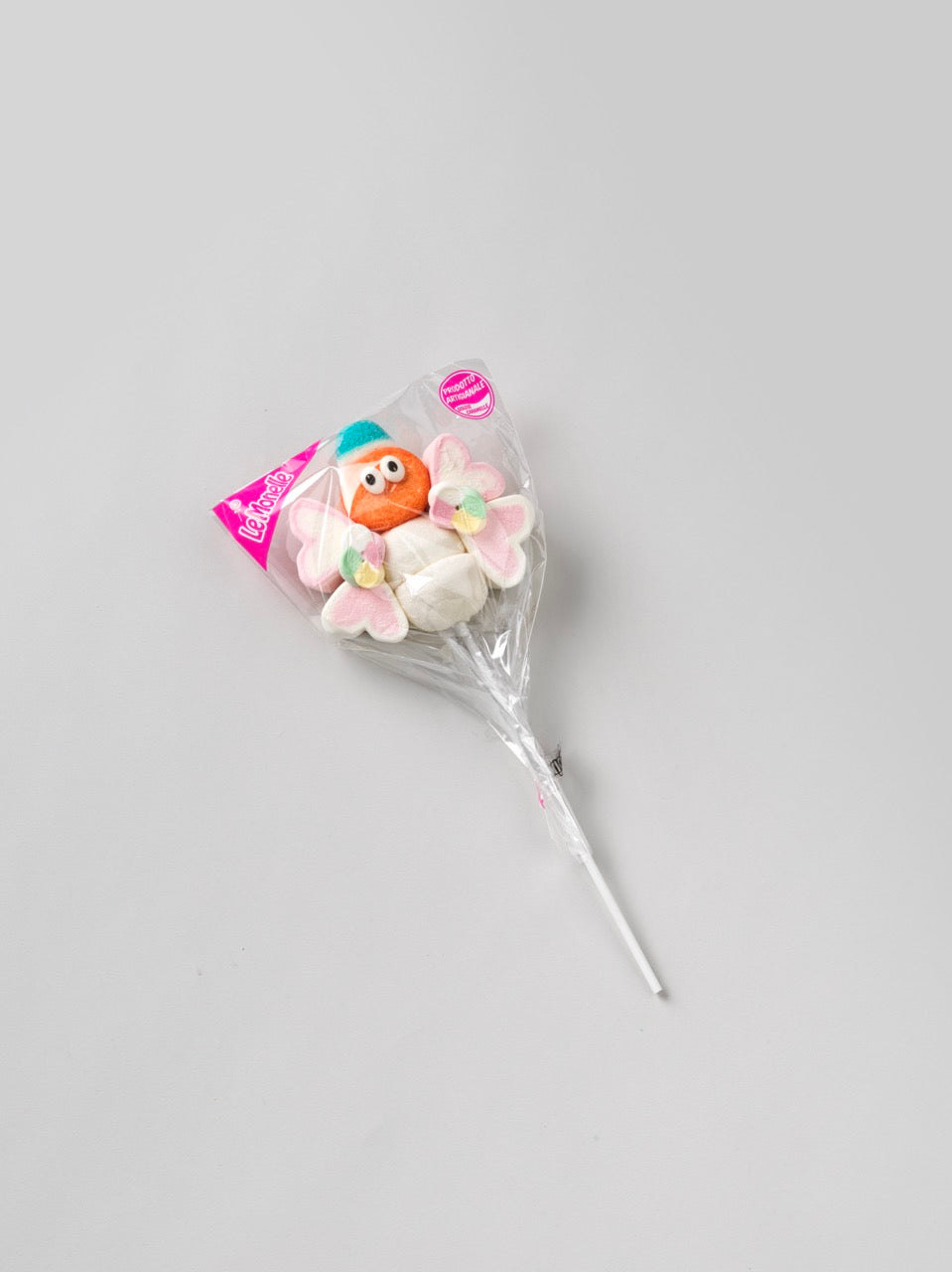 Brochette de guimauve “Papillon” orange sur fond gris – bonbon tendre et coloré aux formes ludiques.