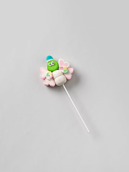 Brochette de guimauve “Papillon” verte sur fond gris – friandise moelleuse et colorée pour moments gourmands.