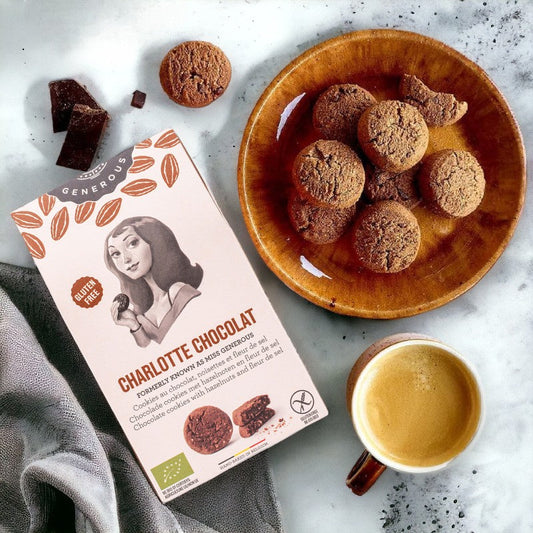 Sachet de biscuits Charlotte, cookies au chocolat, noisettes et fleur de sel bio et sans gluten posé dans une cuisine avec un café, pause gourmande et raffinée.