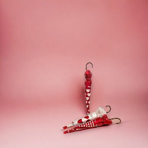 Trois grands parapluies Love en chocolat au lait présentés sur fond rose, gourmandises élégantes et festives pour offrir ou se faire plaisir.