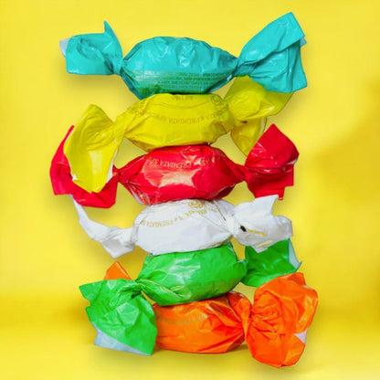 Six Amaretti moelleux Nature empilés dans des emballages colorés, biscuits aux amandes tendres et gourmands.